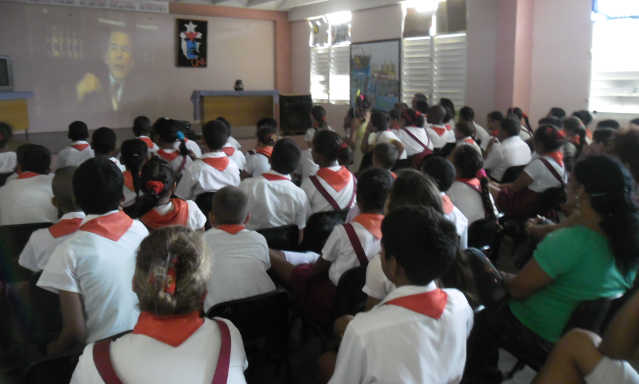 Niños en el teatro de la escuela mirando el documental